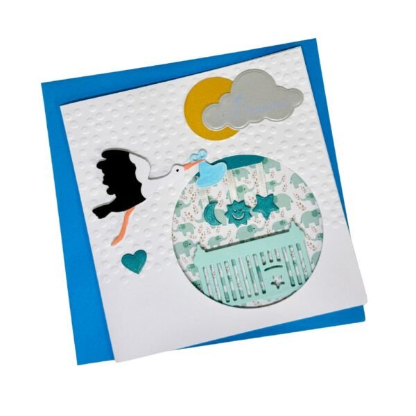 Carte naissance garçon cigogne posée devant son enveloppe blanche irisée.